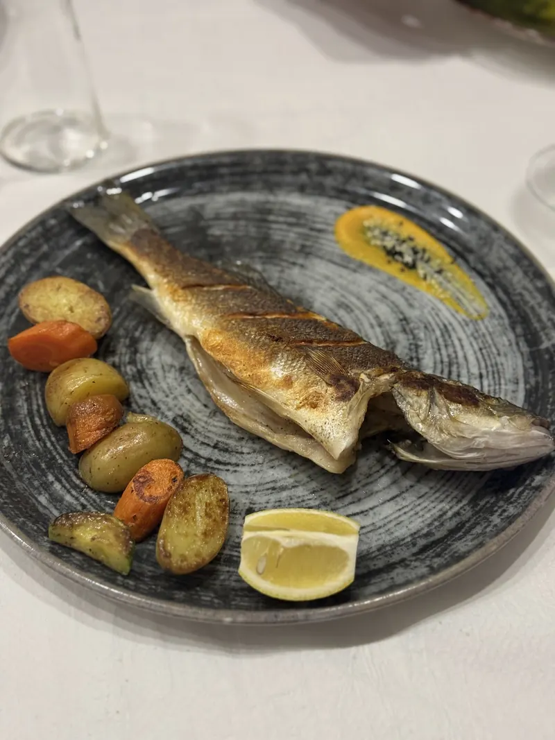 Grilled branzino with roast potatoes, carrots and lemon