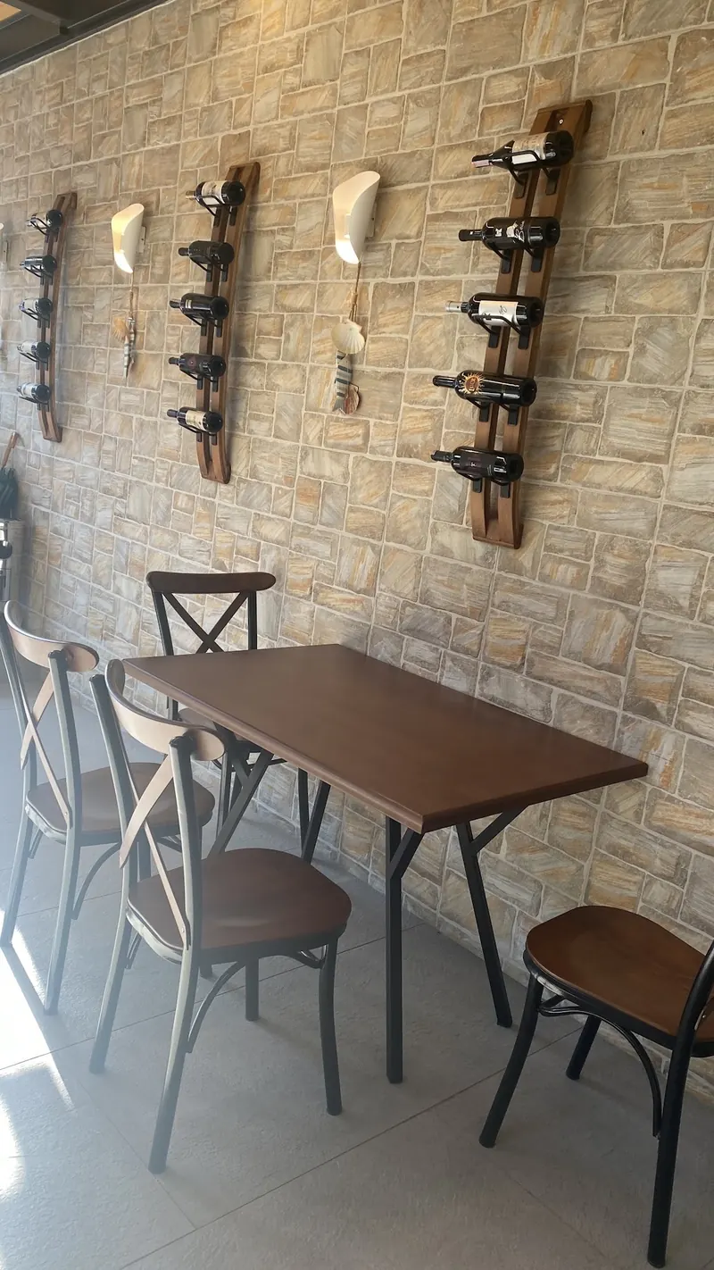 Dining room with a stone wall, wine racks and wooden tables