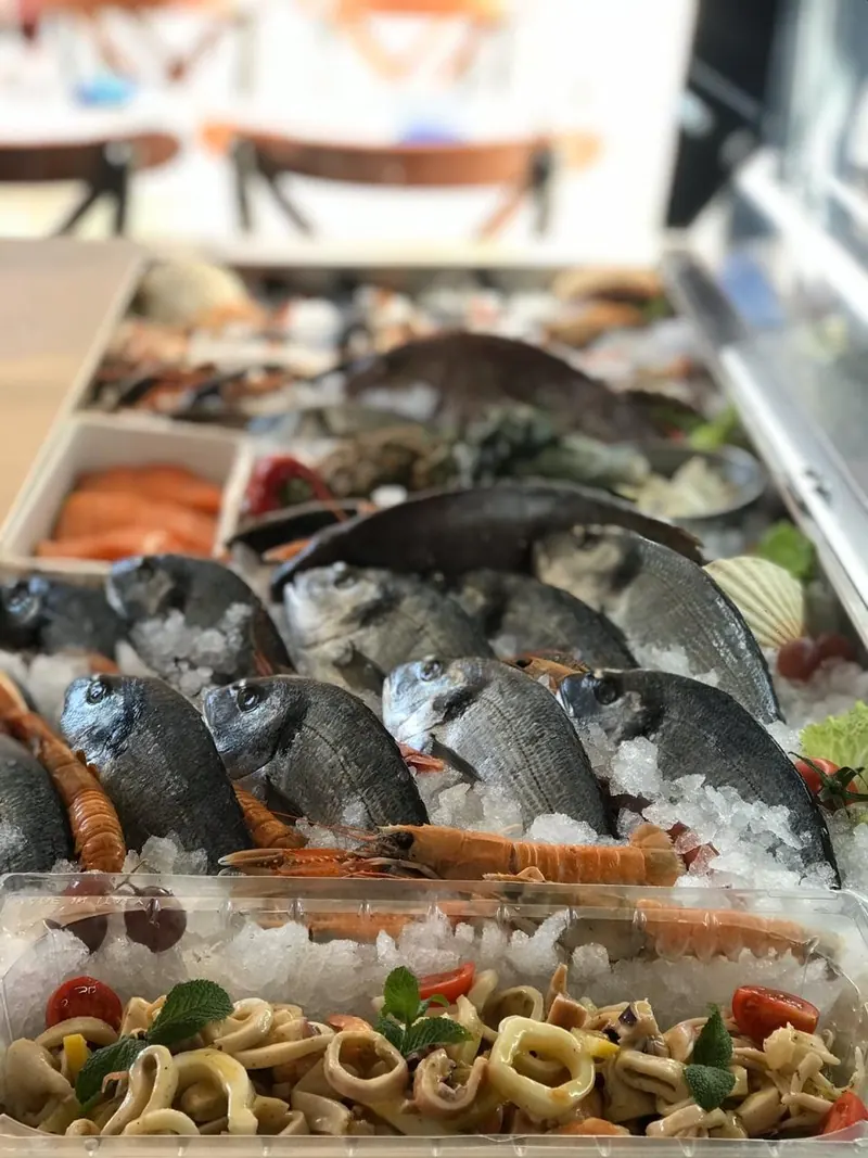 Sea bream, langoustines and calamari salad on ice at the counter