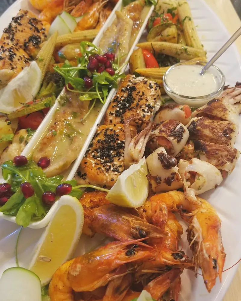 Mixed grill platter with shrimps, calamari, salmon and sesame