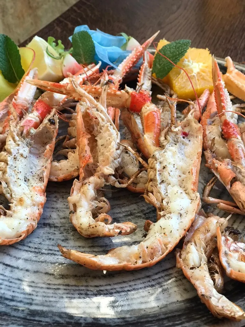 Grilled scampi split open with orange and mint