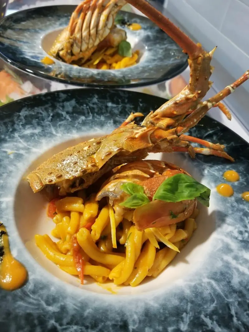 Pasta with lobster and basil on a marble plate