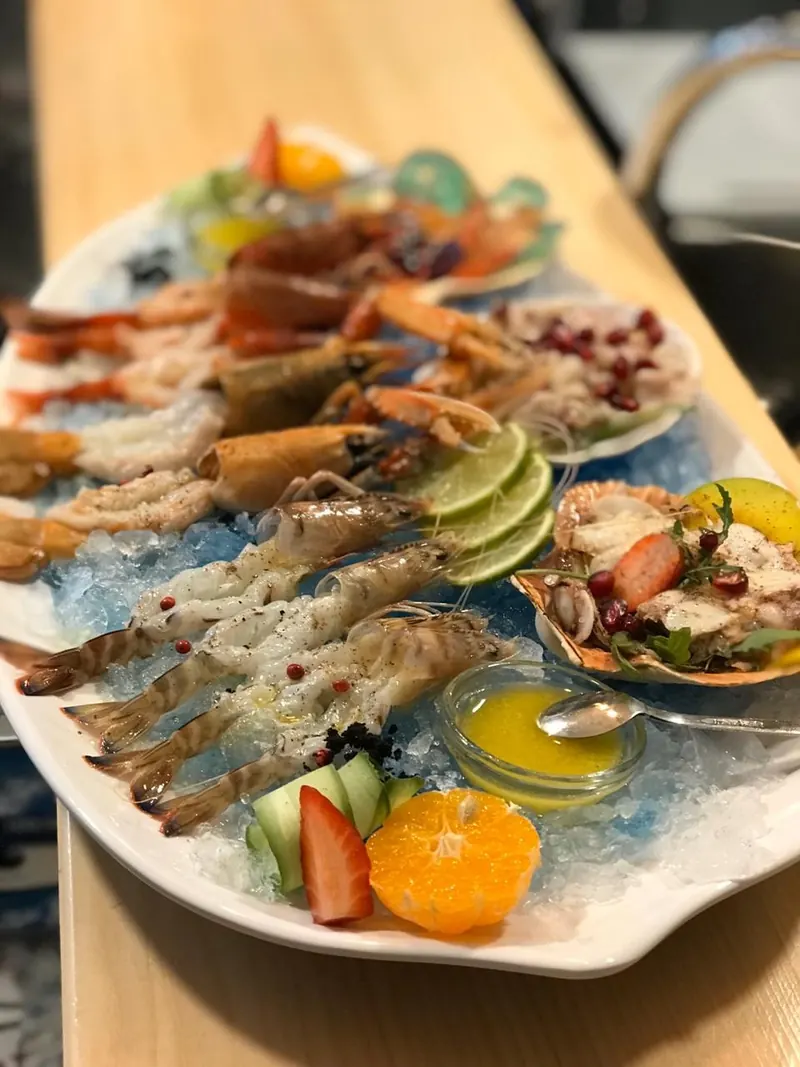 Cold seafood platter with prawns, langoustines and scallops on blue ice