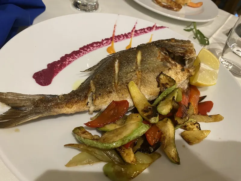 Whole grilled fish with grilled vegetables and lemon