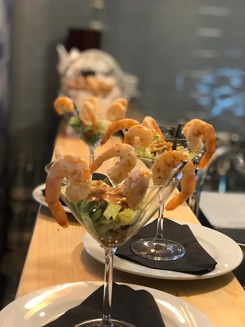 Shrimp cocktails served in martini glasses along the bar
