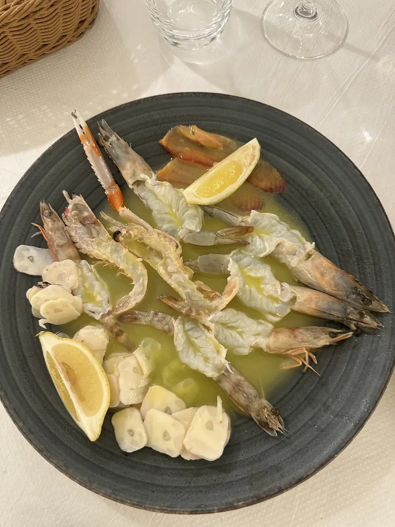 Shrimps with garlic, olive oil and lemon on a dark plate